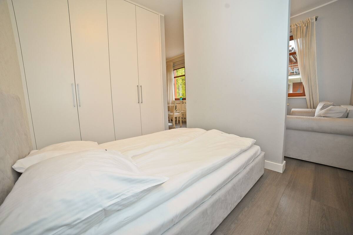 Ein Schlafzimmer mit einem Bett, einem Kleiderschrank und einem Schlafsofa.