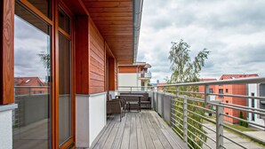 Una terraza de madera con una mesa y sillas, con vista a una zona residencial.
