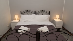 A neatly made bed with white linens, two bedside lamps, and a framed picture above the bed. - B&B Tra L'Etna e il Mare (Catania)