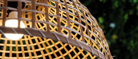 A woven, dome-shaped hanging light fixture with a visible bulb inside.
