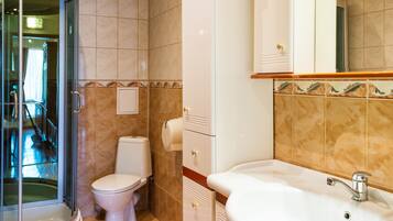 Un baño con inodoro, lavabo y ducha.