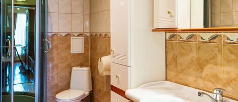 A bathroom with a toilet, sink, and shower.