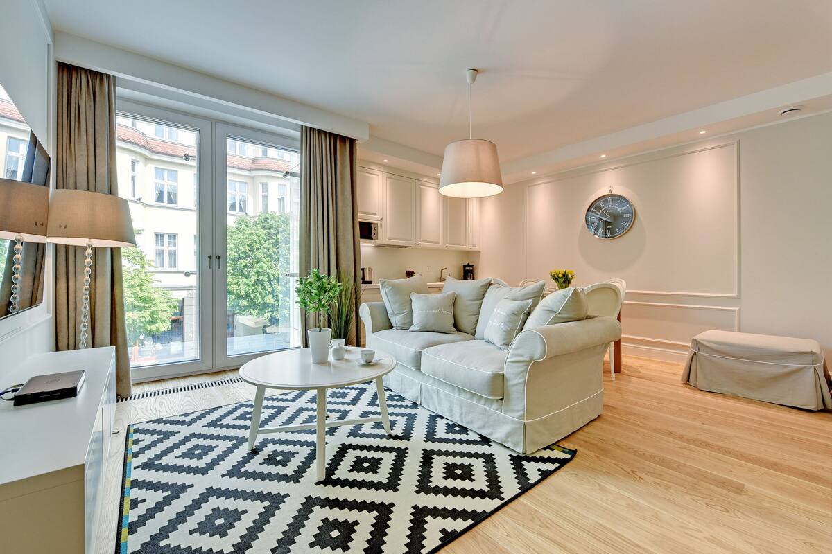 A modern living room with a sofa, a coffee table, and a patterned rug.