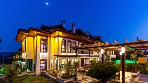 Un edificio amplio y bien iluminado, con varias ventanas y un espacio al aire libre cubierto con mesas y sillas.