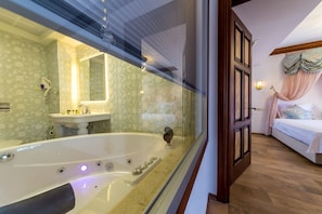 Un baño con una bañera grande, un lavabo y un espejo.