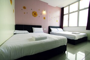 A hotel room with two beds, white linens, and a wall decorated with sunflowers and butterflies.