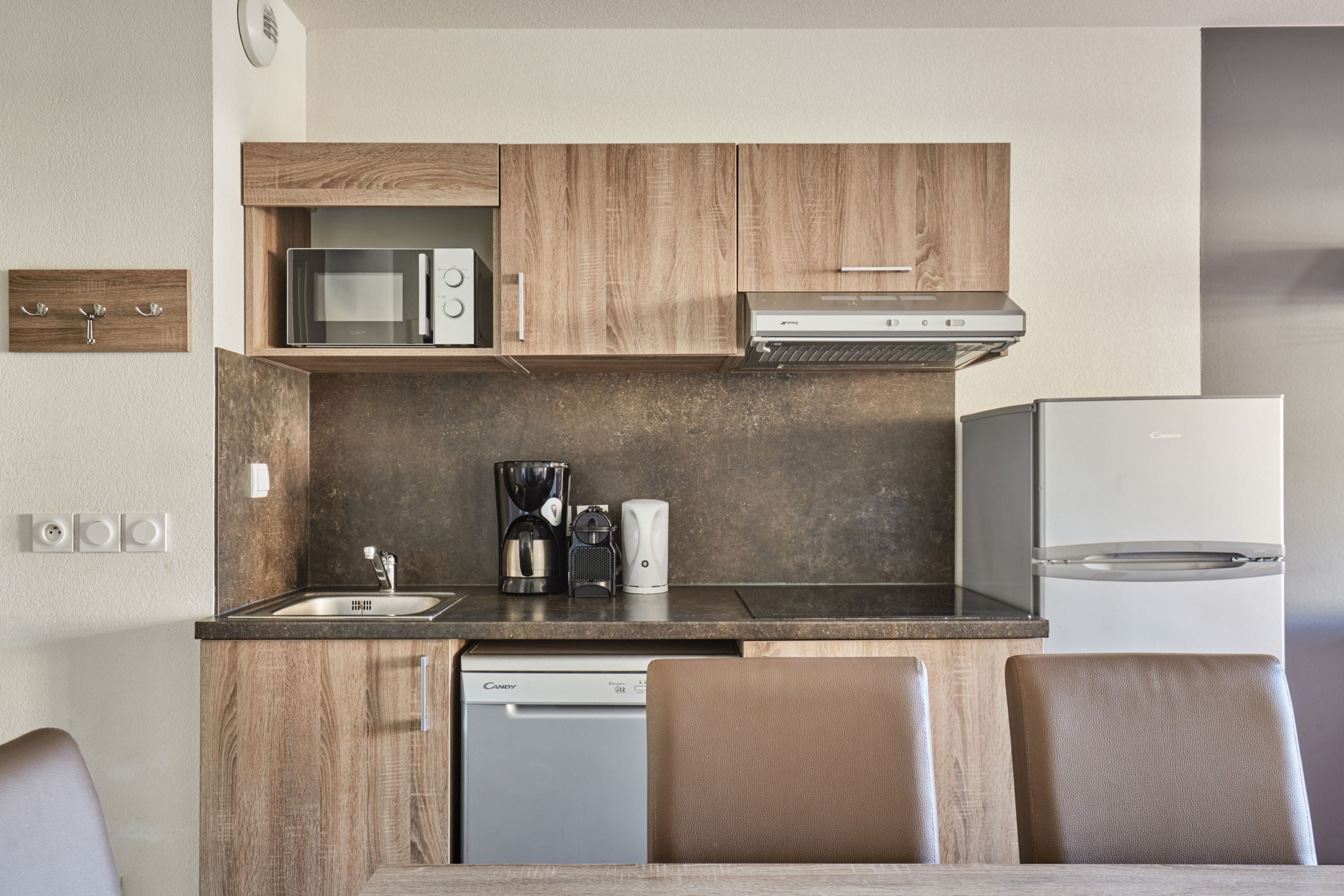 Cocina compacta con microondas, cafetera y lavavajillas.