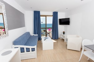 Apartamento superior, 1 quarto, sacada, vista para o mar | Sala de estar | TV de tela plana