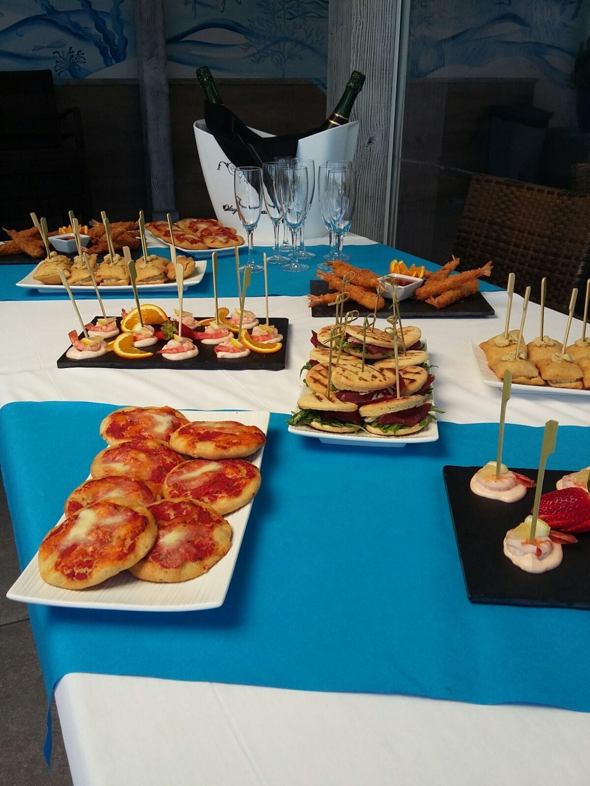 A buffet table with various food items, including bread, sandwiches, and seafood appetizers.