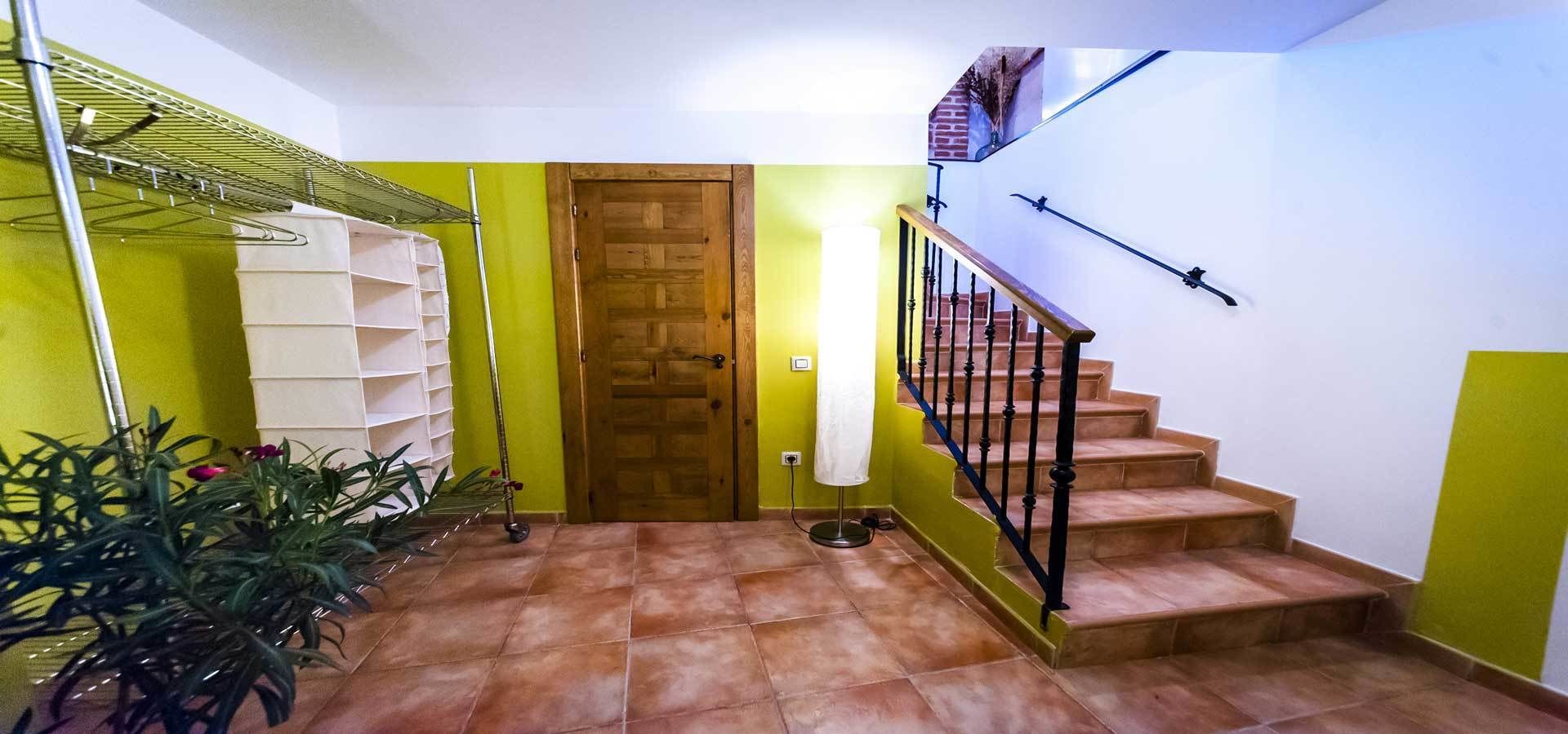 Gradi amb barana de fusta i barana metàl·lica, que condueix a una porta on penja una tovallola blanca.