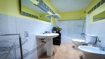 A bathroom with two sinks, a toilet, and a shower.
