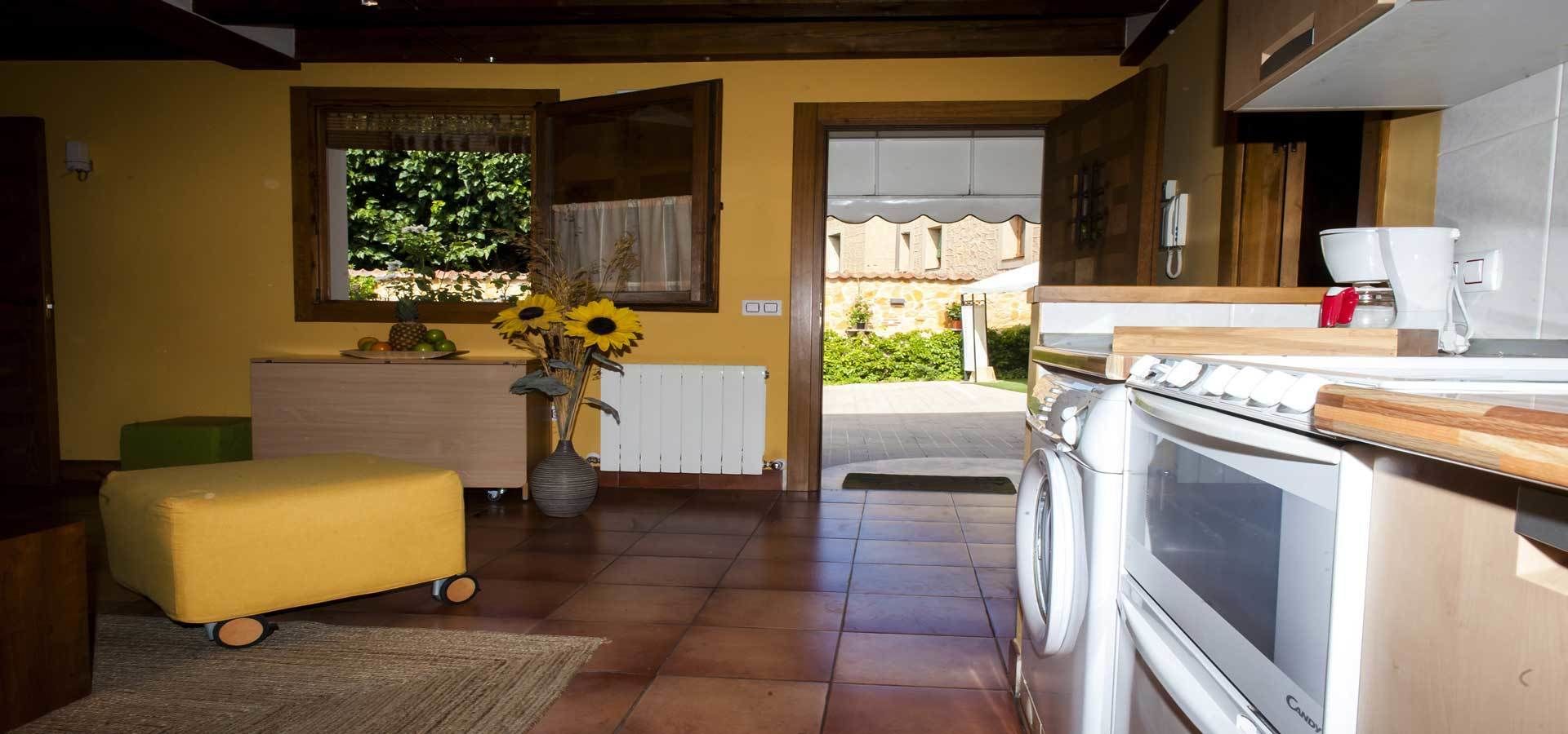 Une cuisine compacte équipée d’un lave-linge, d’un radiateur et d’un petit coin repas avec une table et des chaises.