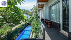 A modern building with a pool, surrounded by lush greenery. - Hotel Blue Dragon (Phu Quoc)