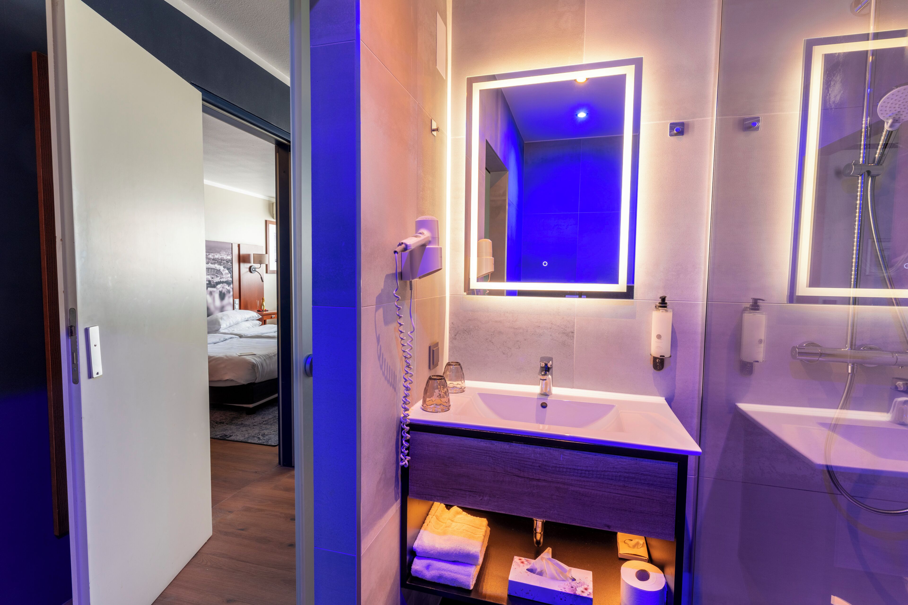 Une salle de bain moderne avec un meuble-lavabo, un miroir et une douche.