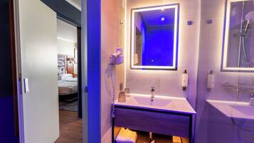 Une salle de bain moderne avec un meuble-lavabo, un miroir et une douche.