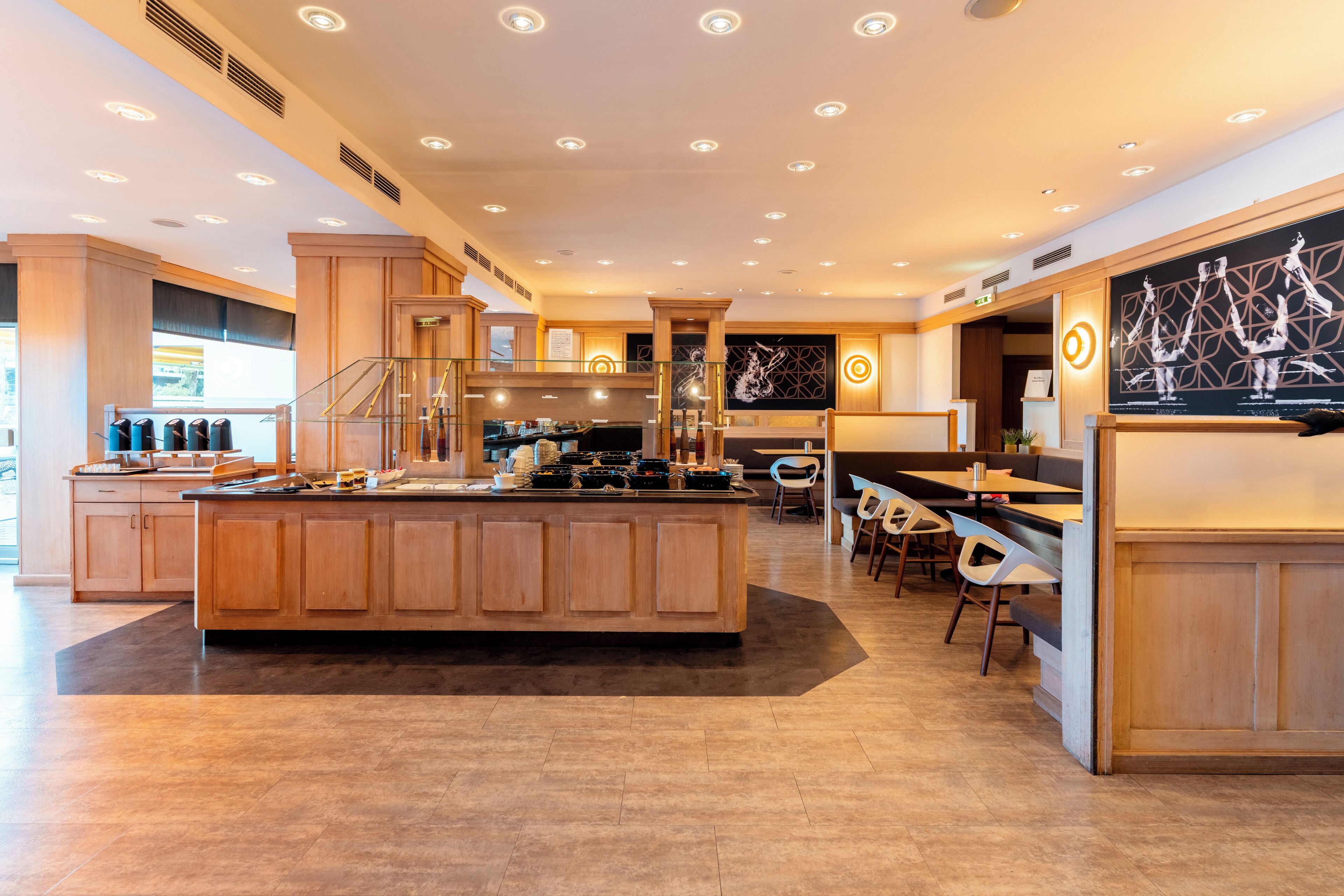 A spacious kitchen with a central island, wooden cabinets, and modern lighting.