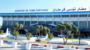 The exterior of the Airport de Tunis-Carthage with a clear view of the building's facade, including the signage in both French and Arabic. - Hotel TEJ (Tunis)