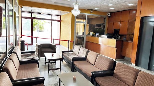 A hotel lobby with seating areas, a reception desk, and a kitchen visible in the background. - Hotel TEJ (Tunis)