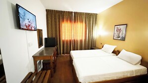 A hotel room with a bed, a desk, a television, and a painting on the wall. - Hotel TEJ (Tunis)