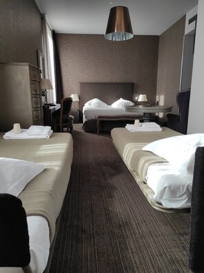 A hotel room with two beds, a desk, a chair, a lamp, and a wardrobe. - Hôtel de Paris (Besancon)