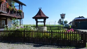 Un edificio tradizionale con un balcone, un gazebo e un giardino recintato.