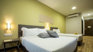 A hotel room with two beds, a nightstand, a wall-mounted air conditioner, and a decorative wall piece. - Humaira Hotel (Tanah Merah)