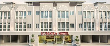 A modern hotel with a symmetrical facade, large windows, and a central entrance.