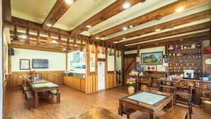 A wooden interior with a dining area, kitchen, and various decorative items. - Sheepman Villa (Ren'ai)