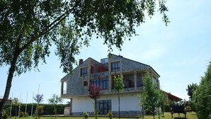 Un edificio de dos pisos con fachada de piedra, varias ventanas y un balcón.