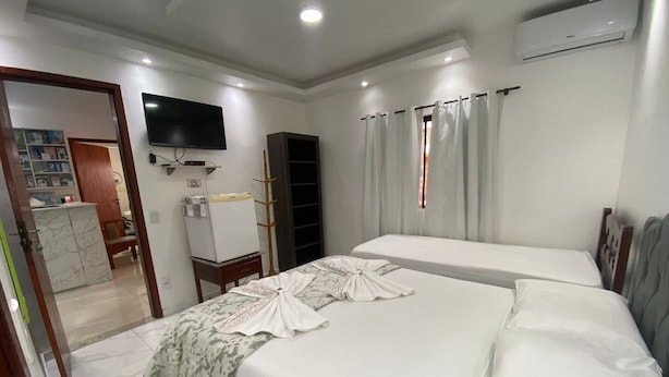Una habitación de hotel con cama, televisión, armario y escritorio.
