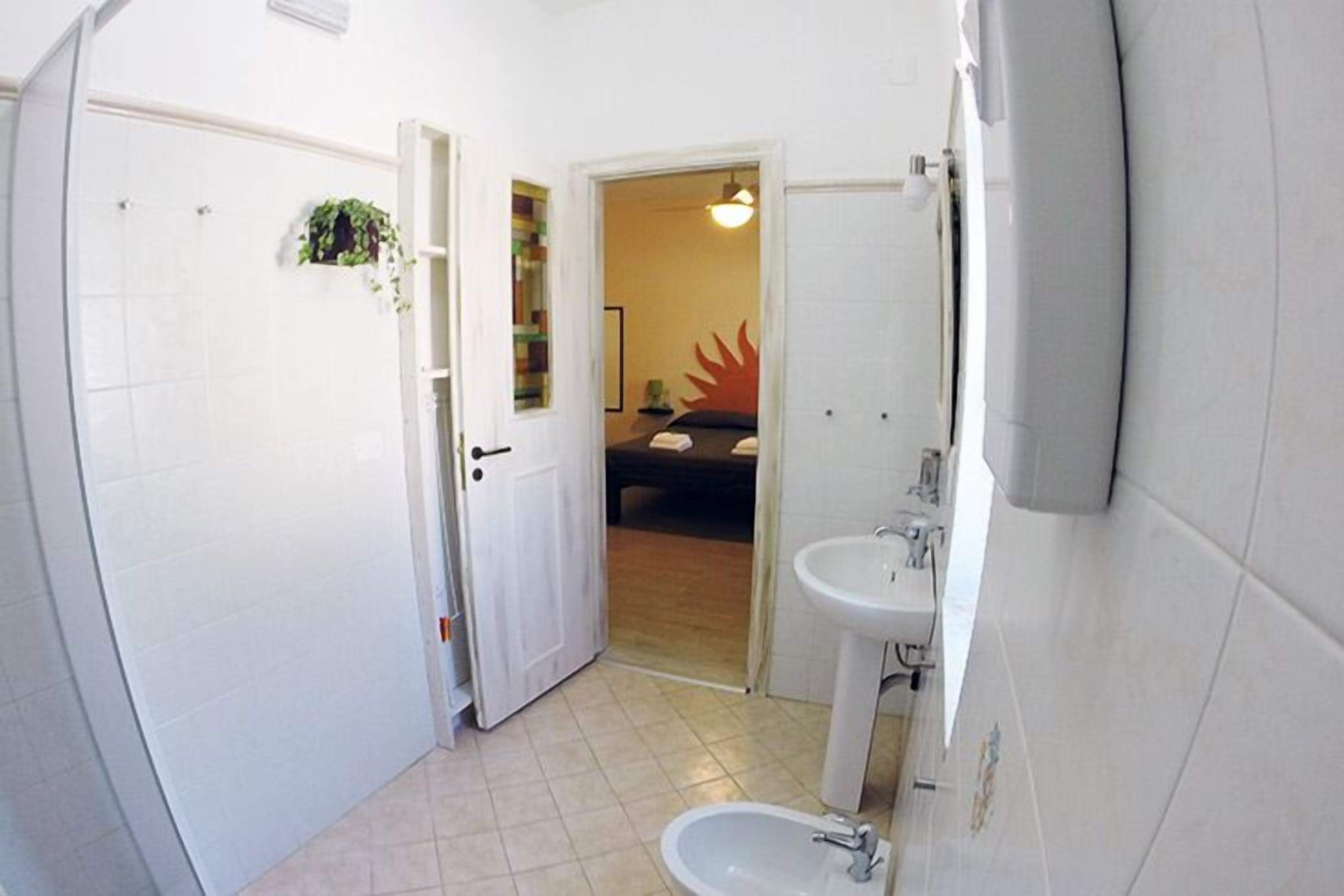 A compact bathroom with a toilet, sink, and shower.