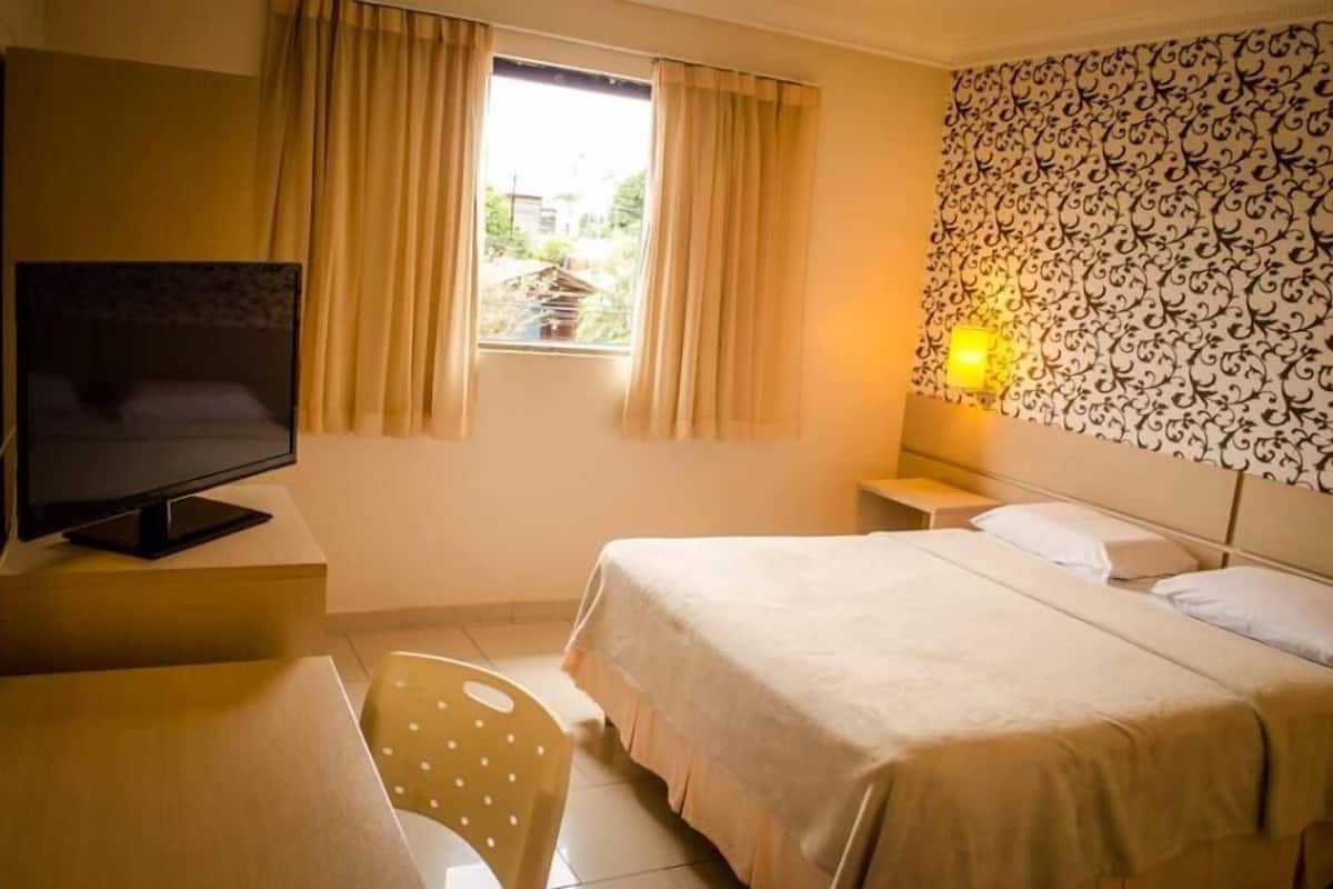 Minibar, escritorio, cortinas blackout y tabla de planchar con plancha