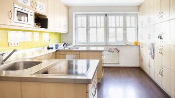 A modern kitchen with wooden cabinets, a stainless steel sink, and a window providing natural light.