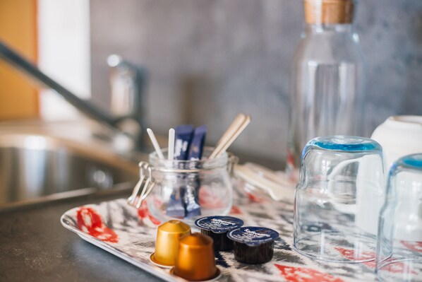 A tray with various containers, including a jar with utensils, a bottle, and several small jars with lids. - myNext - Riverside Hotel Salzburg (Salzburg)