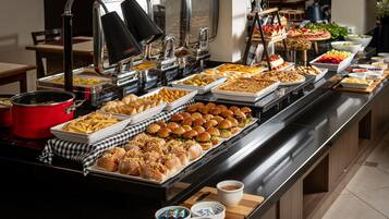 Ein Buffet mit verschiedenen Speisen, darunter Sandwiches, Salate und Desserts.