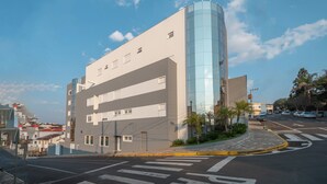 A modern building with a curved glass facade, multiple windows, and a flat roof. - Hotel Kindermann (Cacador)