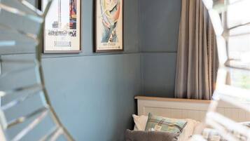 A bedroom with a bed, pillows, and two framed posters on the wall.