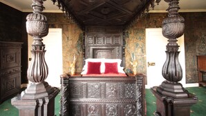 A bedroom with a large, ornate bed, a wooden ceiling, and a green carpet. - Appleby Castle (Appleby-in-Westmorland)