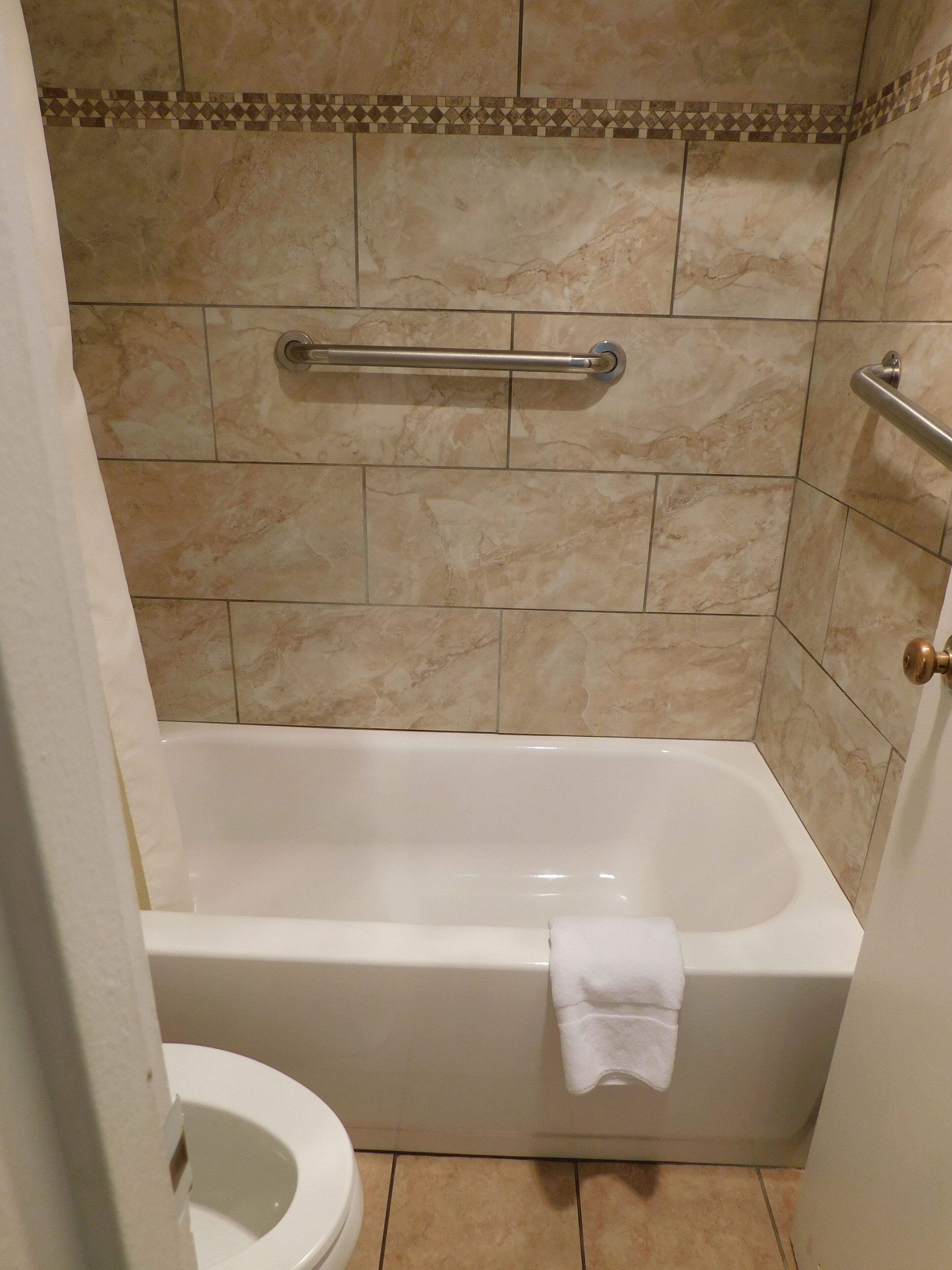 Un baño con bañera, inodoro y zona de ducha.