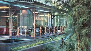 A modern building with a glass facade, outdoor seating area, and a water feature. - Best Western Plus Coco Palu (Palu)