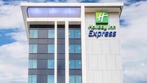 A Holiday Inn Express building with a modern design, featuring large windows and a prominent green logo. - Holiday Inn Express Adelaide City Centre by IHG (Adelaide)