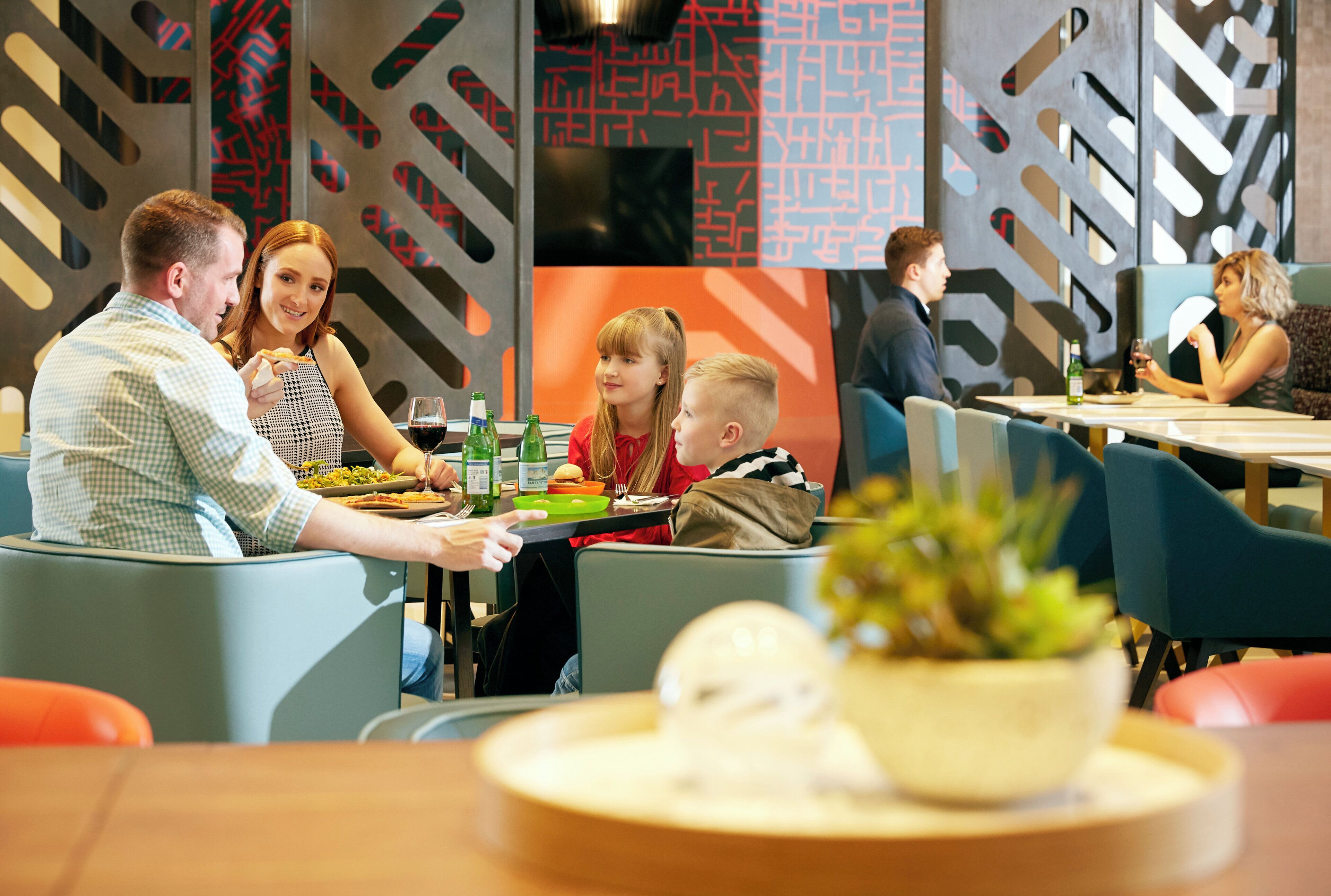 Un restaurante con decoración moderna, que incluye patrones geométricos en las paredes y mobiliario contemporáneo.