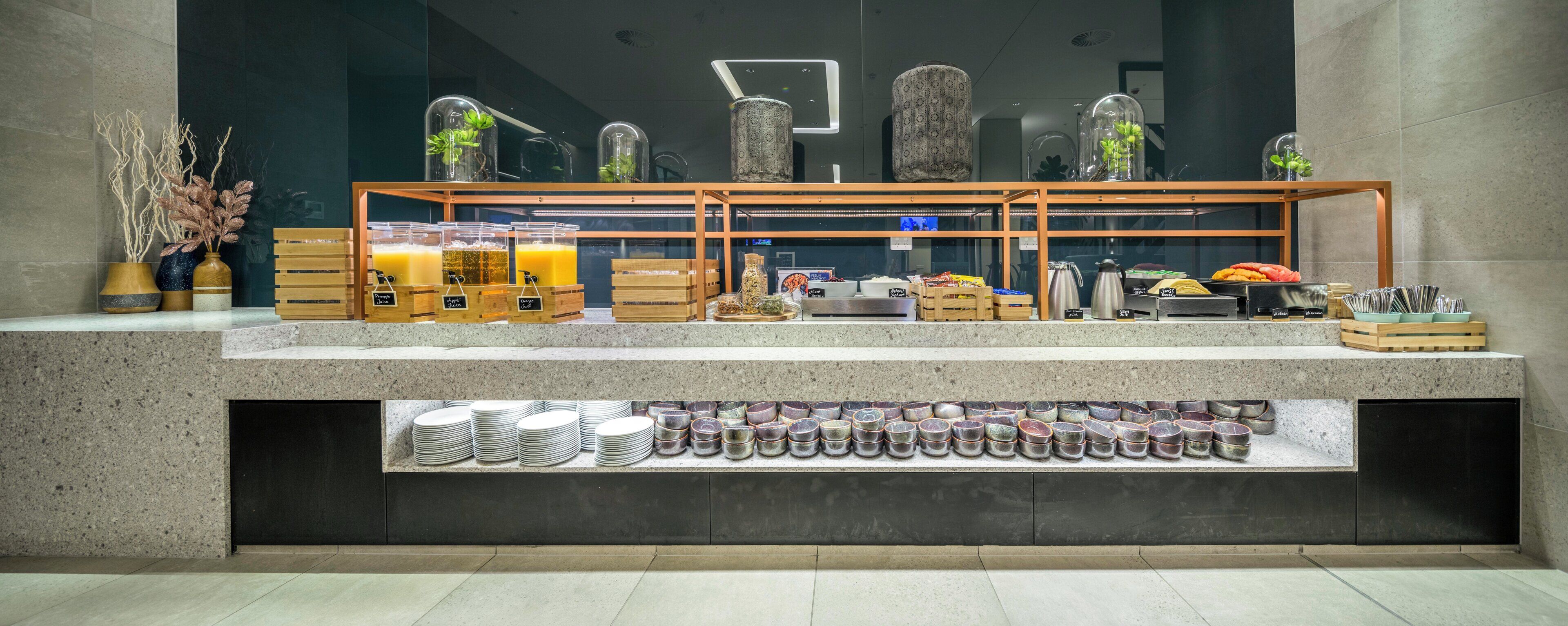 A buffet setup with various food items and drink dispensers.