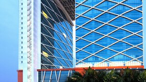 A modern high-rise building with a distinctive geometric facade and a prominent central atrium.
