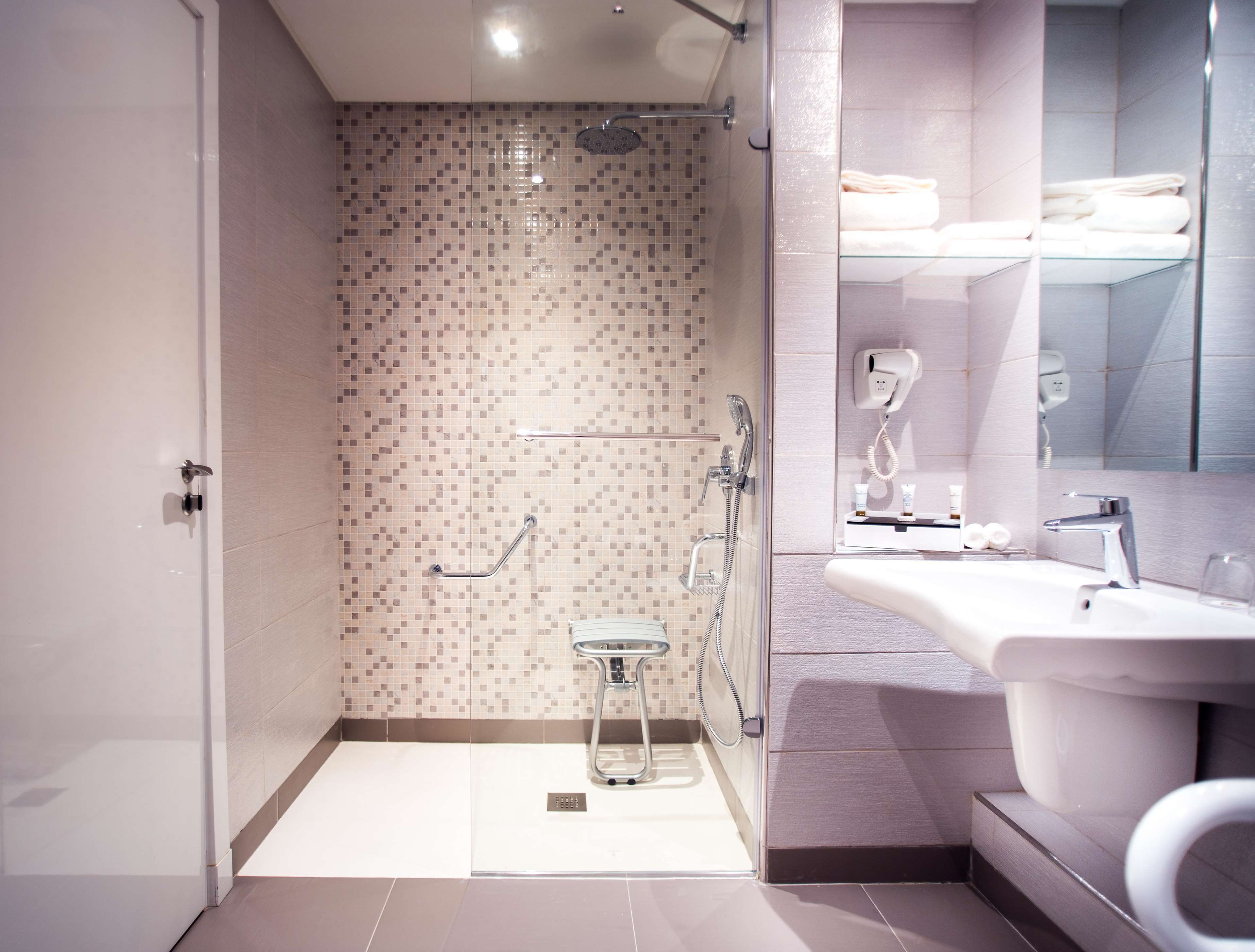 A modern bathroom with a shower, toilet, and sink.