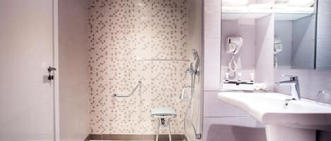 A modern bathroom with a shower, toilet, and sink.