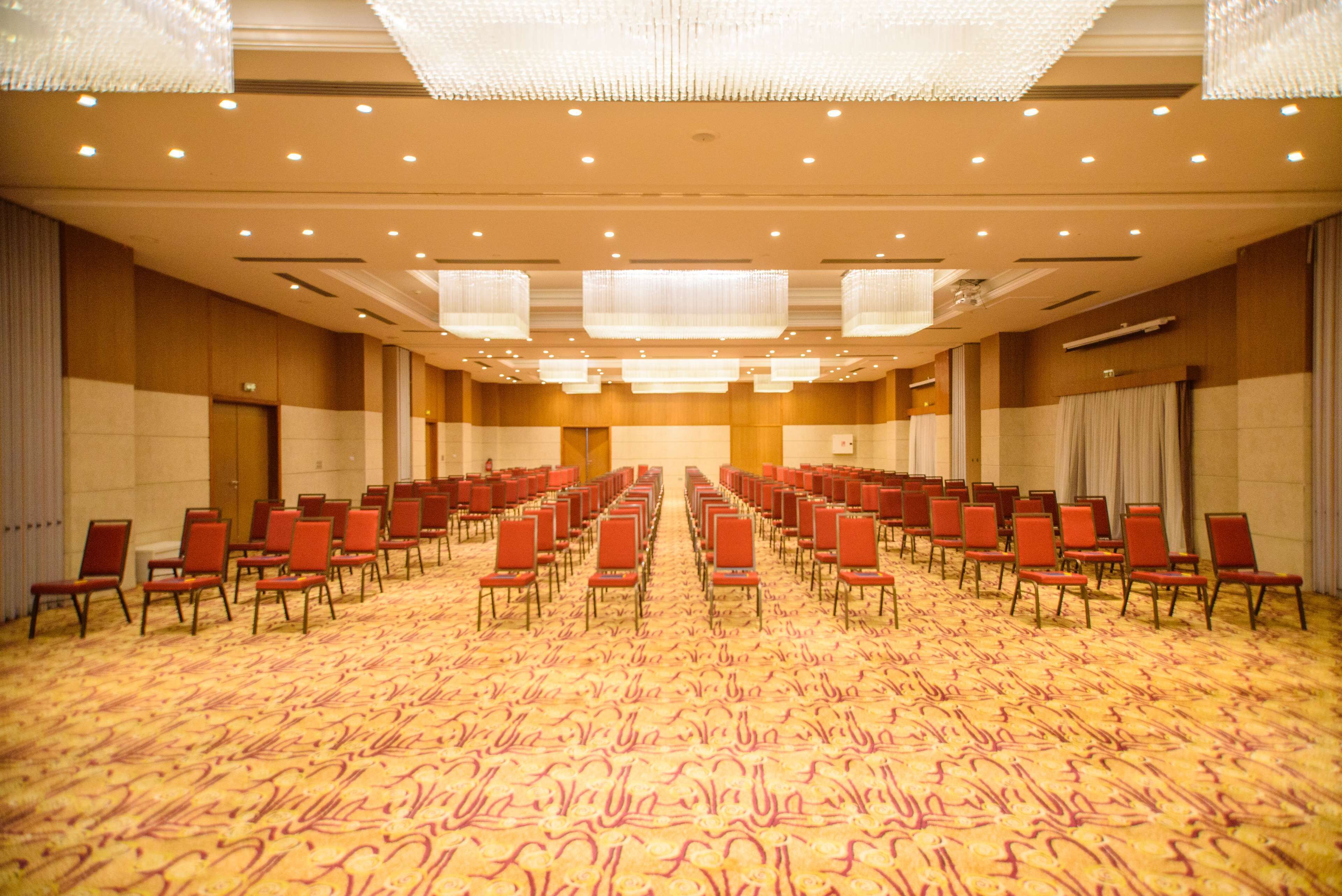 A large conference room with rows of chairs and a carpeted floor.