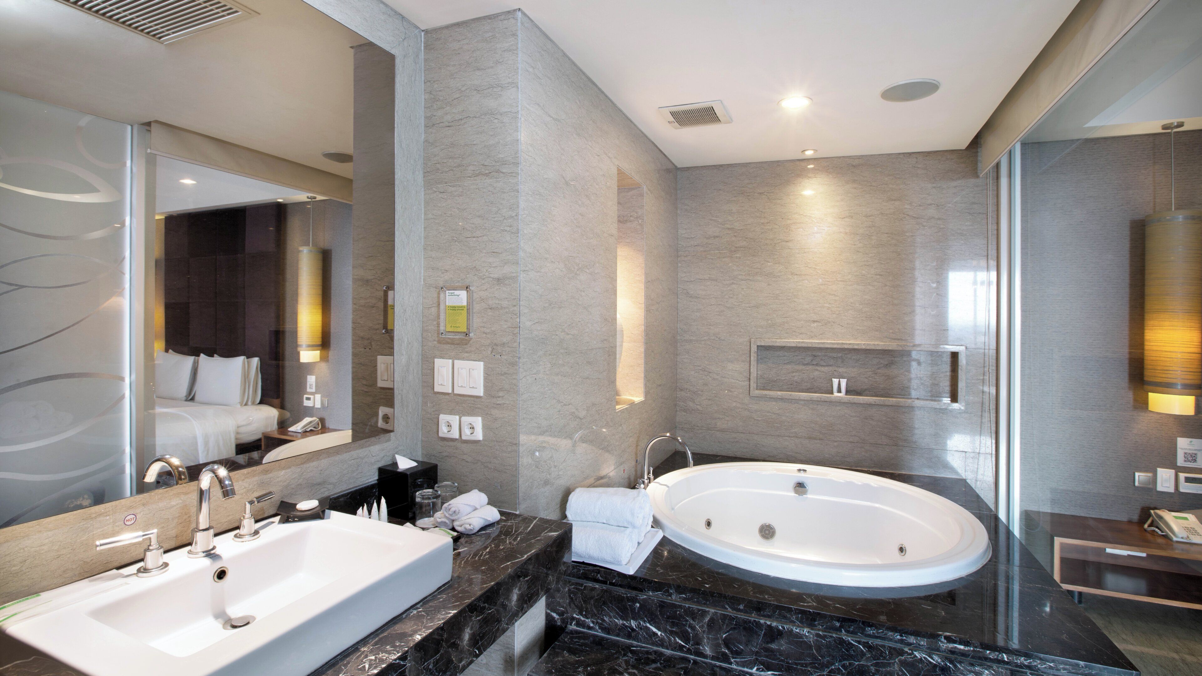 Une salle de bain moderne avec un grand lavabo, une baignoire et un miroir.