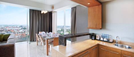 A modern kitchen with a large island, wooden cabinets, and a view of the city.