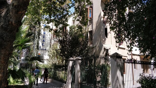Ein baumbewachsener Weg führt zu einem Gebäude, an dem ein Schild mit der Aufschrift "Hotel Stal" zu sehen ist.